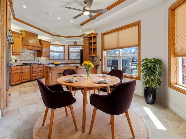 dining area with ceiling fan, recessed lighting, baseboards, a raised ceiling, and crown molding