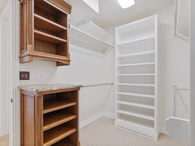 walk in closet featuring light carpet