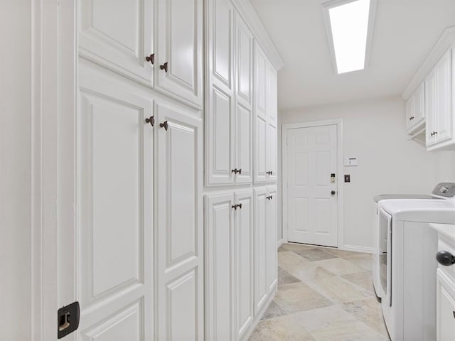 washroom featuring cabinet space, baseboards, and independent washer and dryer