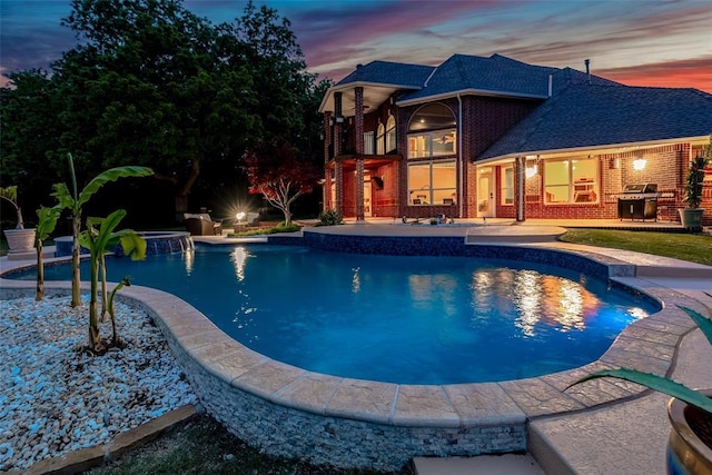 pool with an in ground hot tub, grilling area, and a patio