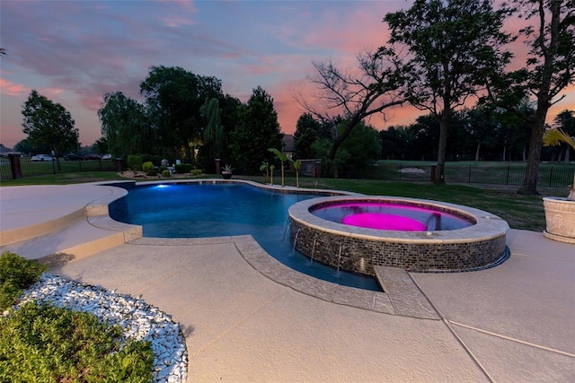 view of pool featuring a patio, a yard, fence, and a pool with connected hot tub