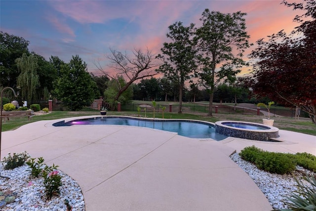 view of pool featuring a yard, a pool with connected hot tub, fence, and a patio