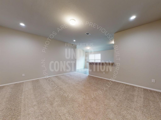 carpeted empty room featuring baseboards, visible vents, and recessed lighting