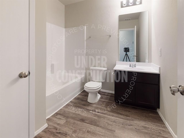 bathroom with bathtub / shower combination, toilet, wood finished floors, vanity, and baseboards