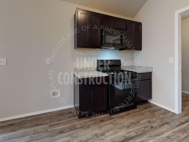 kitchen with dark wood-style floors, light stone counters, black appliances, dark brown cabinets, and baseboards