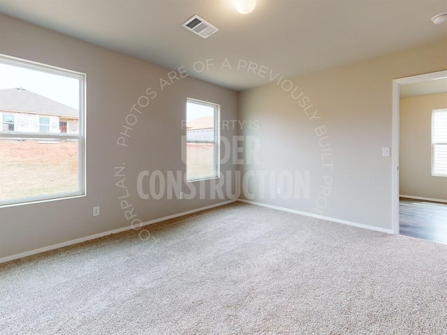 carpeted spare room with baseboards and visible vents