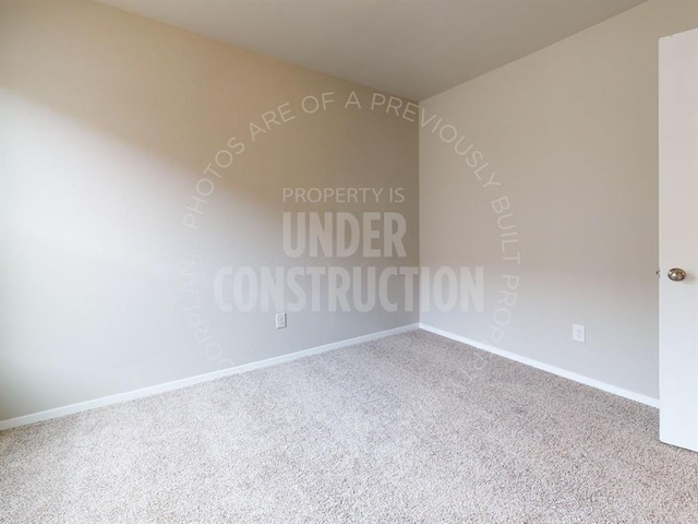 unfurnished room with carpet and baseboards