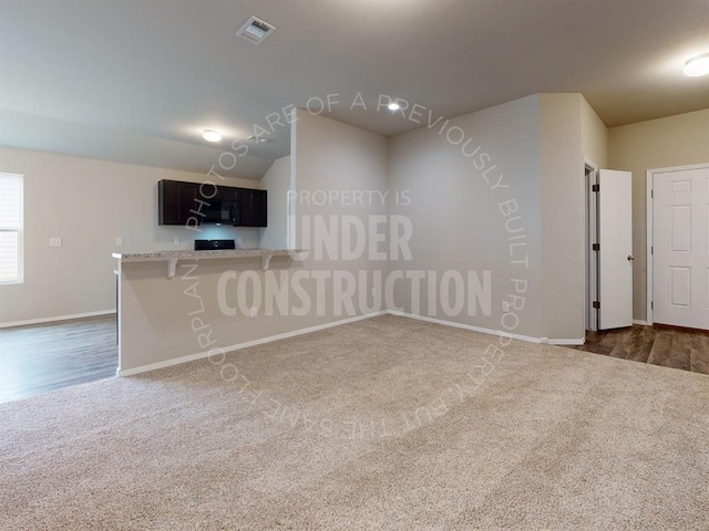 spare room featuring baseboards, visible vents, and dark colored carpet