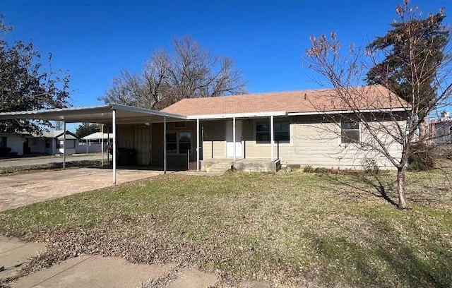 view of front facade with driveway, a carport, and a front yard