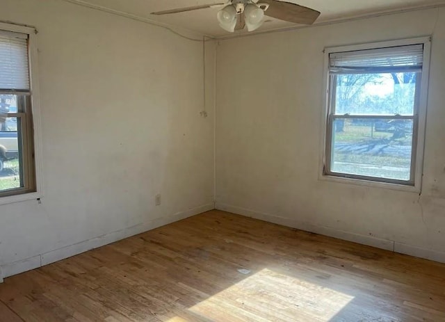 unfurnished room with a ceiling fan, baseboards, and wood finished floors