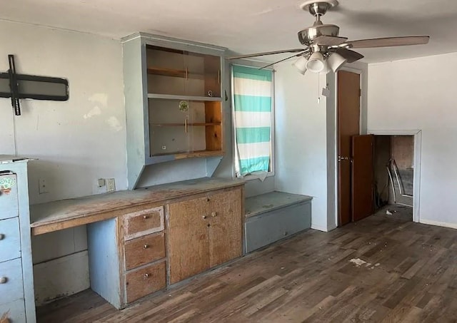 unfurnished office with ceiling fan and dark wood-type flooring