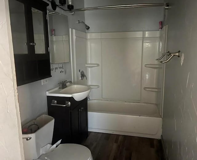 full bathroom with toilet, tub / shower combination, wood finished floors, and vanity