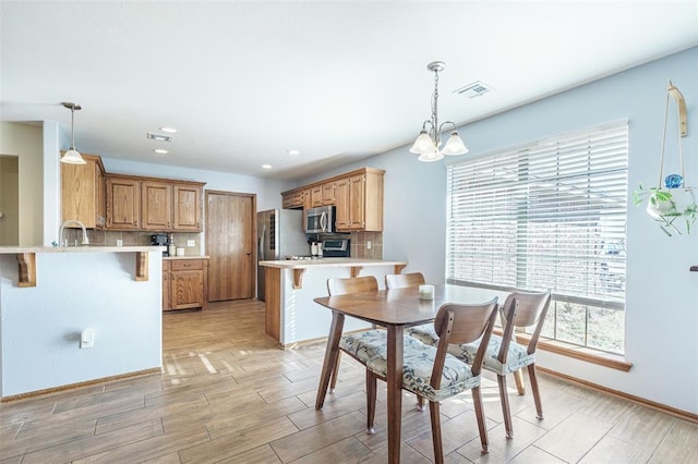 dining area featuring light wood-type flooring, recessed lighting, visible vents, and a chandelier