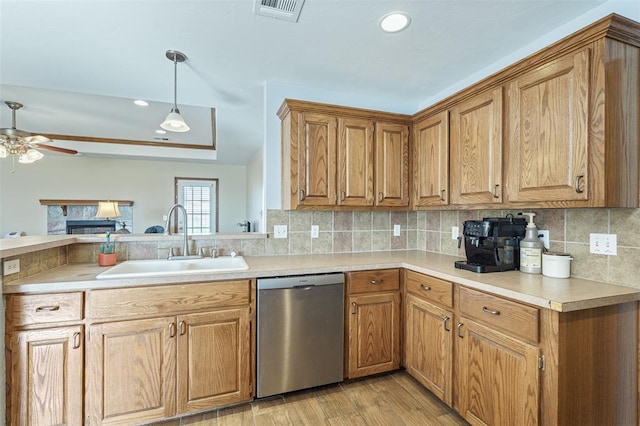 kitchen with visible vents, light countertops, decorative backsplash, stainless steel dishwasher, and a sink