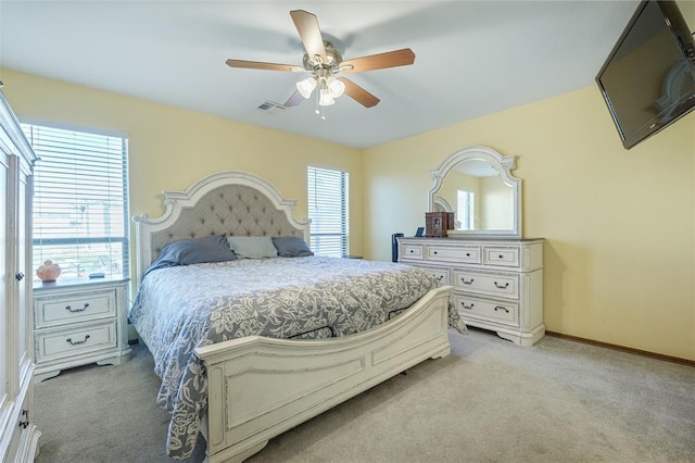 bedroom with visible vents, baseboards, light colored carpet, and ceiling fan