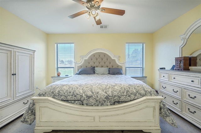 bedroom featuring multiple windows, visible vents, and dark colored carpet