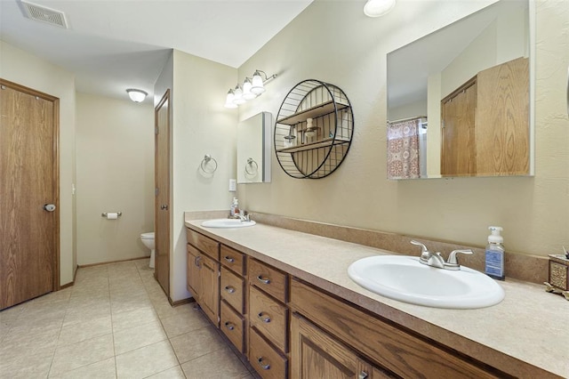 full bath featuring tile patterned floors, visible vents, toilet, and a sink