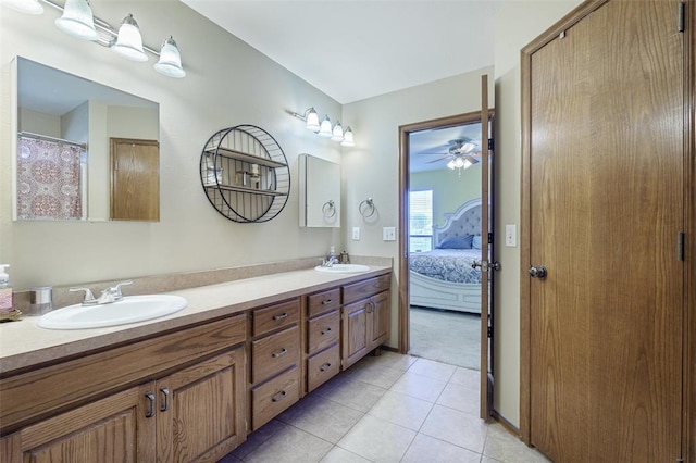 ensuite bathroom with tile patterned flooring, double vanity, connected bathroom, and a sink