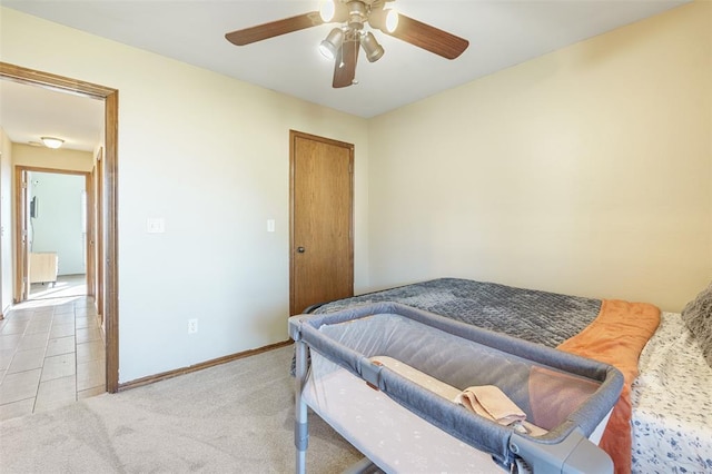 bedroom with light carpet, a ceiling fan, radiator heating unit, a closet, and baseboards