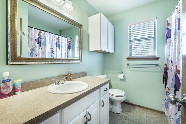 bathroom featuring toilet, vanity, and tile patterned flooring