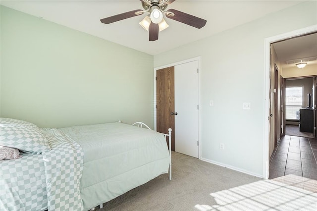 carpeted bedroom featuring baseboards and ceiling fan