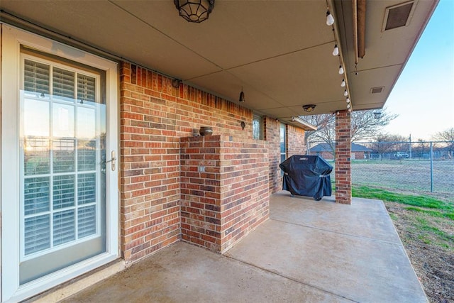 view of patio / terrace featuring area for grilling, visible vents, and fence