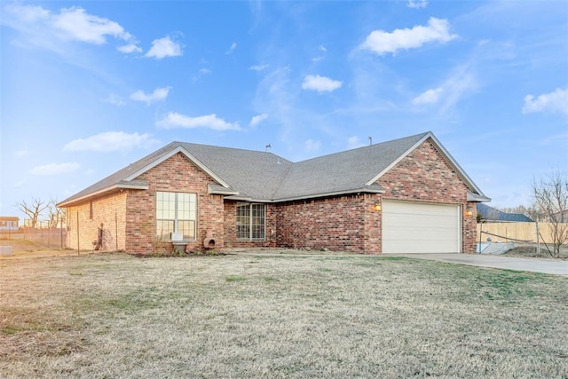 ranch-style home with brick siding, a front lawn, concrete driveway, roof with shingles, and an attached garage