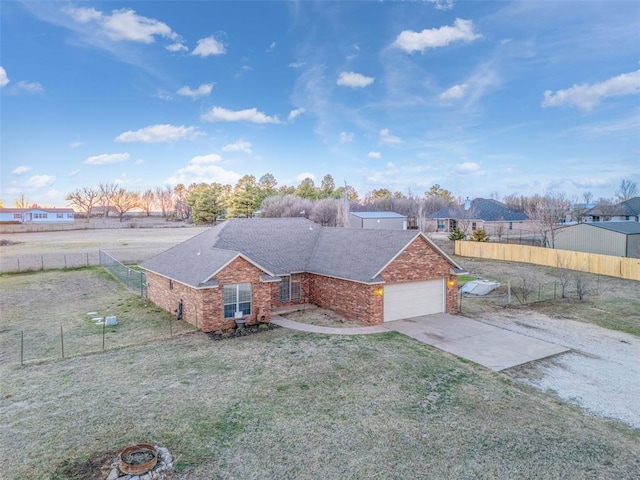 view of front of home with driveway, fence, an attached garage, a front yard, and brick siding