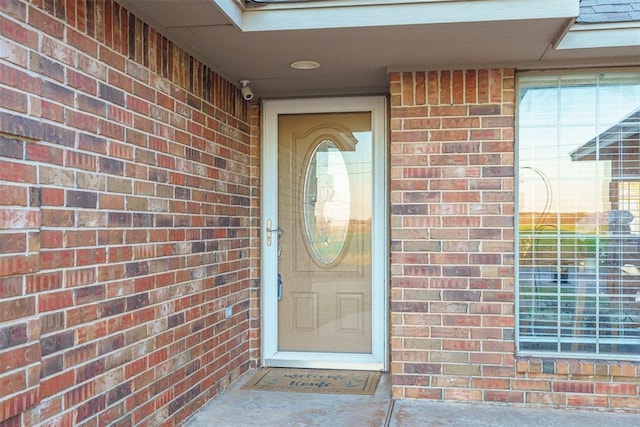 view of exterior entry featuring brick siding