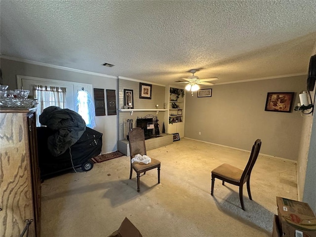 sitting room with visible vents, ornamental molding, and a fireplace with raised hearth