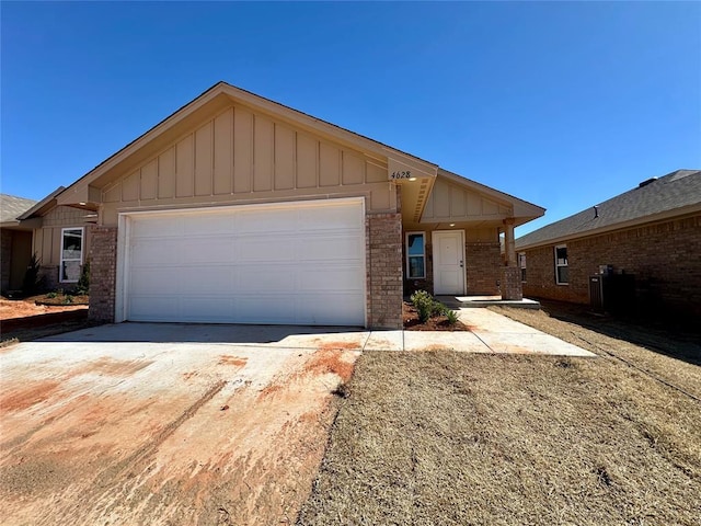 single story home with board and batten siding, brick siding, driveway, and an attached garage