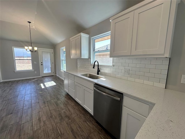 kitchen with backsplash, white cabinets, vaulted ceiling, a sink, and dishwasher