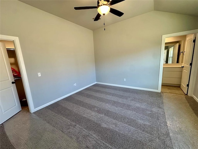 carpeted empty room featuring lofted ceiling, ceiling fan, and baseboards