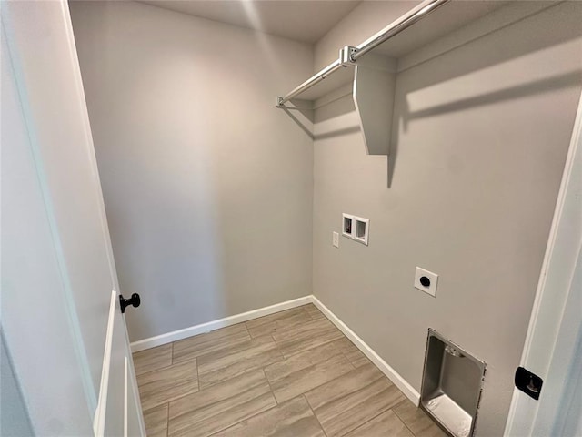 clothes washing area featuring laundry area, washer hookup, electric dryer hookup, and baseboards