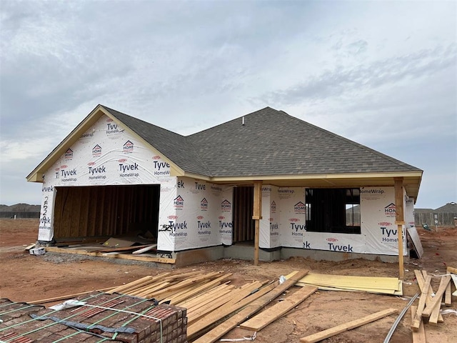 property in mid-construction featuring a garage and a shingled roof