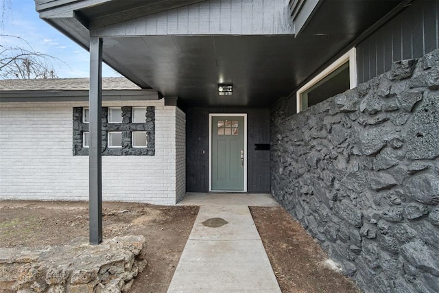 doorway to property with brick siding