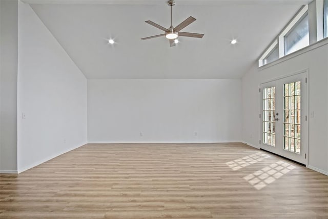 unfurnished living room featuring french doors, light wood-style floors, a ceiling fan, high vaulted ceiling, and baseboards