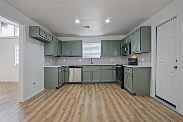 kitchen with appliances with stainless steel finishes, visible vents, decorative backsplash, and green cabinets