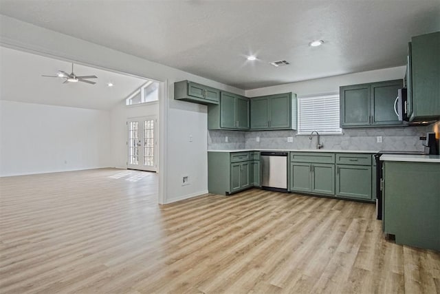 kitchen featuring decorative backsplash, lofted ceiling, stainless steel appliances, french doors, and green cabinetry