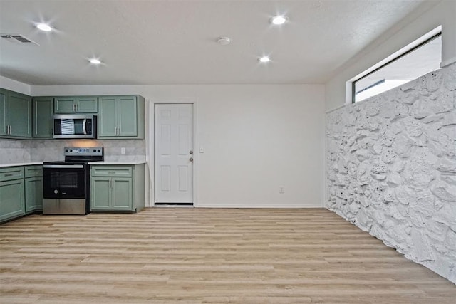 kitchen with light countertops, visible vents, appliances with stainless steel finishes, light wood-type flooring, and green cabinetry