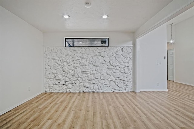 spare room with baseboards and wood finished floors