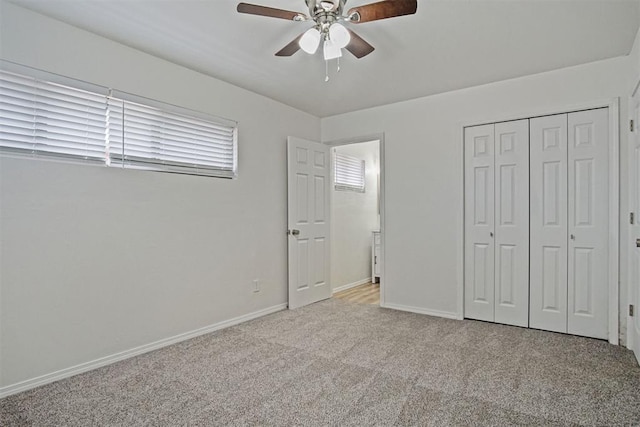 unfurnished bedroom with a ceiling fan, a closet, light colored carpet, and baseboards