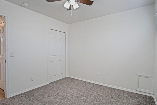 unfurnished bedroom with carpet floors, ceiling fan, baseboards, and a closet