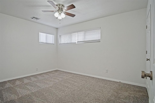 carpeted empty room featuring visible vents, ceiling fan, and baseboards