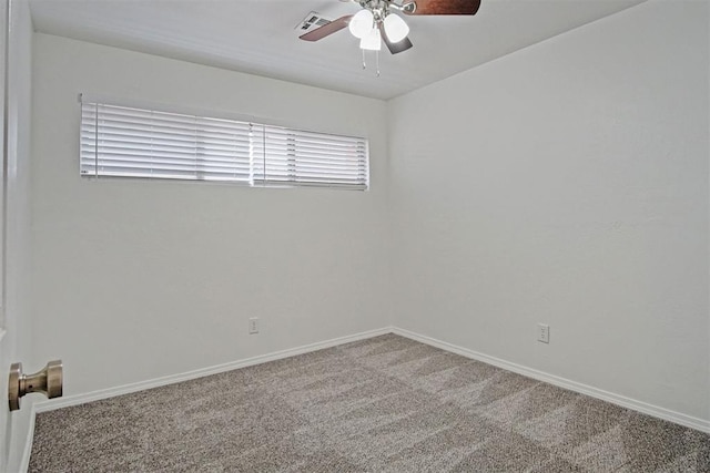 carpeted spare room with visible vents, ceiling fan, and baseboards