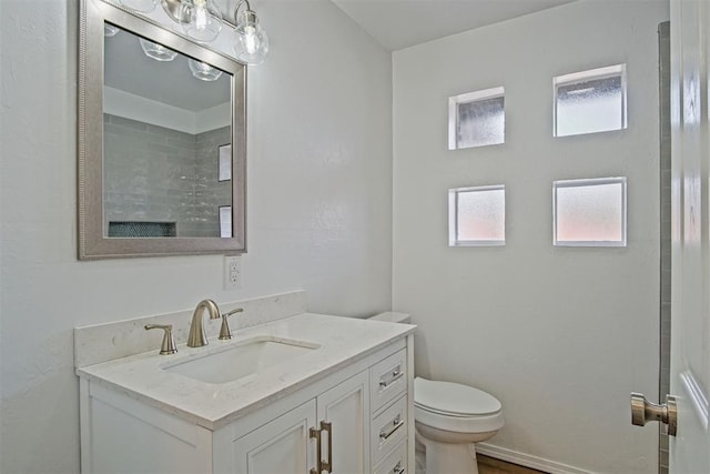 bathroom featuring vanity, toilet, and walk in shower