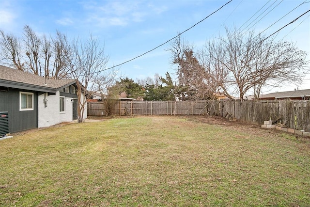 view of yard featuring central AC and a fenced backyard