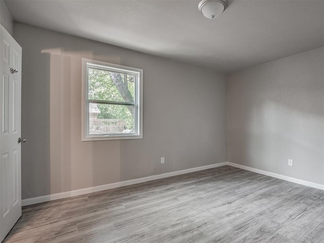 empty room with wood finished floors and baseboards