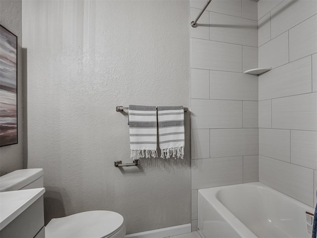 full bath featuring toilet, vanity, baseboards, and a textured wall