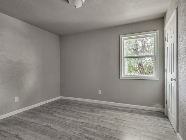 empty room featuring wood finished floors and baseboards